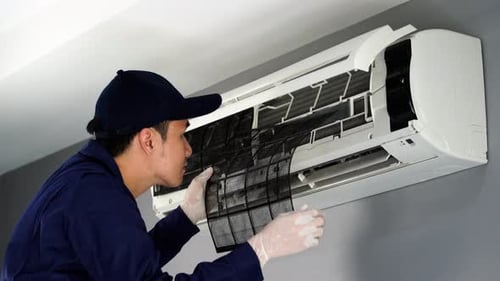 technician service removing air filter of the air conditioner for cleaning