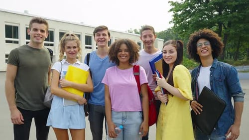 Diverse Students Laughing at Camera Against College
