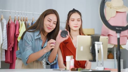 Hermosa bloguera de belleza Influencer mujer transmisión en vivo y mostrando el pincel de maquillaje a los seguidores.