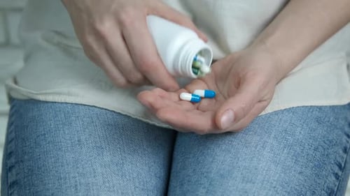 Pills Being Poured into Hand from Bottle