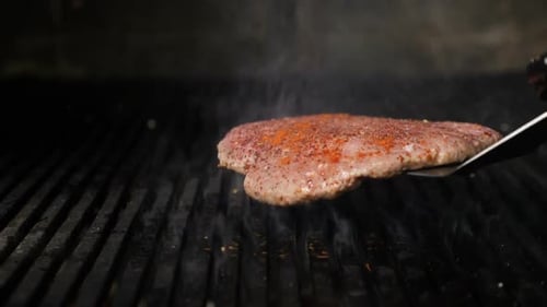 Close-up Shot of Tasty Delicious Burger Patty Flipped on Hot Seared Grill. Chef Preparing Burger