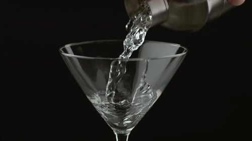Pouring Clear Drink into Martini Cocktail Glass