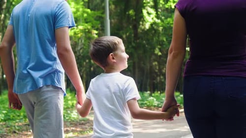 A Family of Three is Walking in the Park