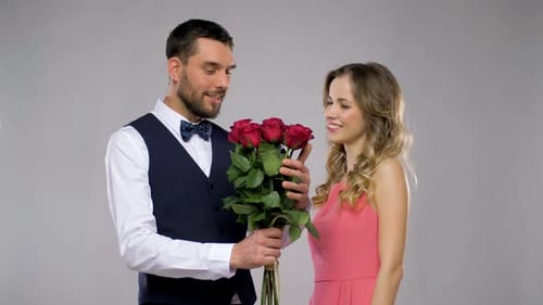 Man Presents Roses to Smiling Woman