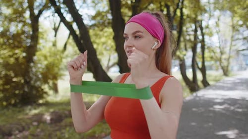 Woman Exercising with Resistance Band in Park