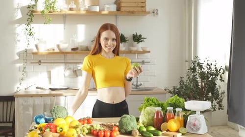 Woman With Apple and Orange in Bright Kitchen