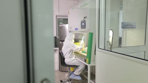 Scientist Works Inside Lab in Protective Suit