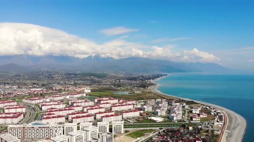 Aerial View of Adler, Sochi Beach, Town and Mountains. Waterfront Stretches Across the Coastline in