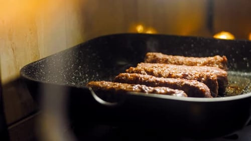 Pink Sausages are Fried on a Grill Pan