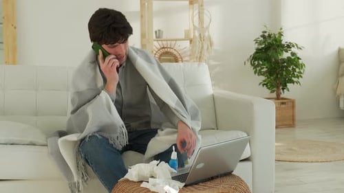 Sick Man Talking on Phone on Couch