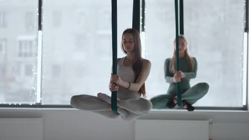 Trainer and Young Woman Practising Aero Gymnastics with Suspensions at Gym