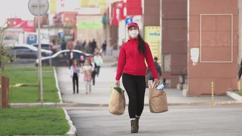 Courier (or a housewife, a cook) with a packages of food on the street. Coronovirus pandemic