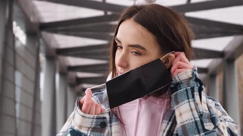 Young Woman Puts on Black Face Mask