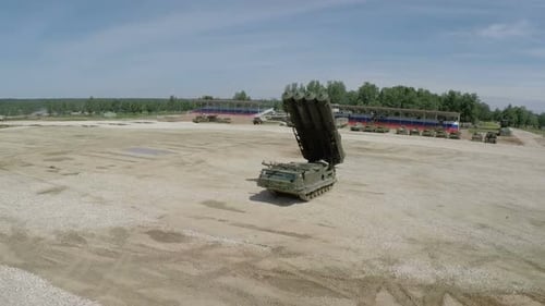 Survol d'un lance-missiles et de chars sur le terrain de tir