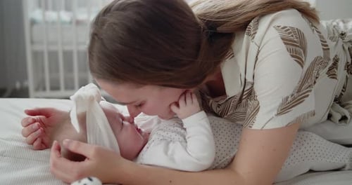 Affectionate Mother Bonding with Baby on Bed