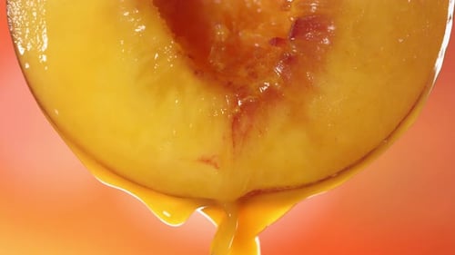 Slow Motion Macro Shot of Flowing Peach Juice From Half Peach