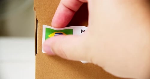 Applying Made in Brazil Label to Cardboard Box