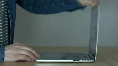 Man Opens Laptop and Types on Keyboard