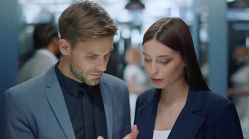 Young Business Couple Talking Over Plan in Office, Colleagues Discussing Project