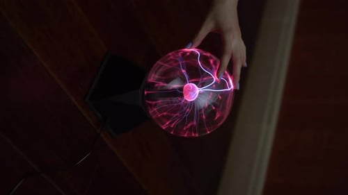 The Female Hand Touches the Plasma Ball, Distributing Small Lightnings. Experiments with Electricity