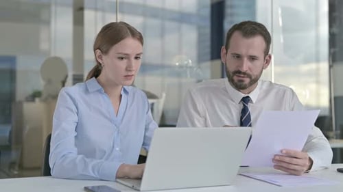 Executive Business People Reading Documents and Using Laptop