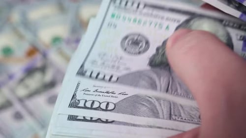 Hand Counting Stack of One Hundred Dollar Bills