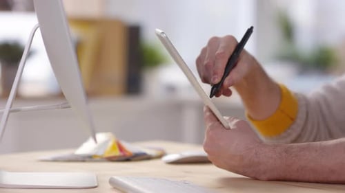 Person Using Stylus on Tablet at Desk