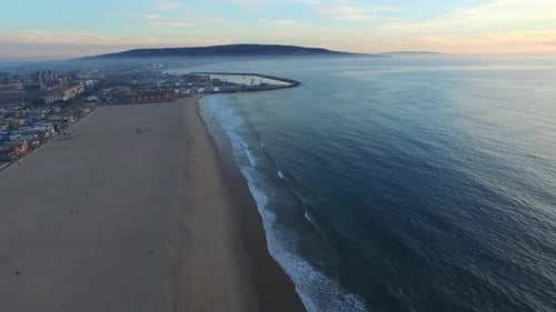 Aerial shot of a scenic beach city and ocean at sunset.