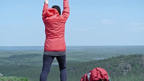 Female Tourist Waving with Smoke Bomb from Mountain Top