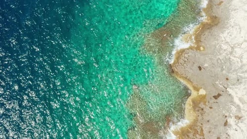 Küstenszene mit azurblauen Meereswellen, die am Felsstrand rollen