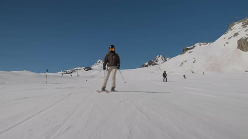 Woman Skiing Quickly Down Mountain Ski Slope Under Blue Sky