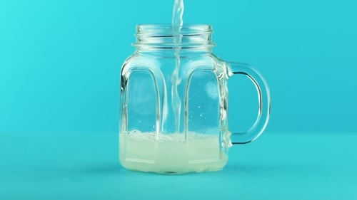 Mug aux fruits, limonade, soda, boisson froide, pooring dans un bocal en verre, bleu
