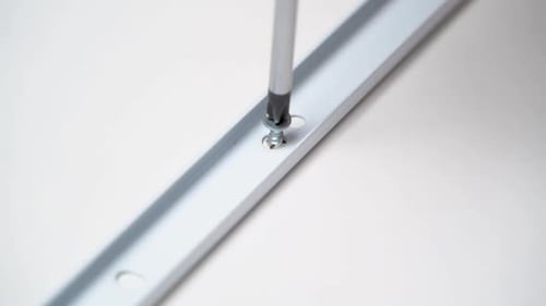 Screwdriver Tightening Silver Screw into Silver Metal