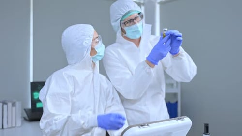 Scientists Examine Vaccine Vial in Laboratory