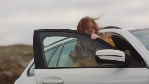 Adolescente pelirroja bajándose del coche