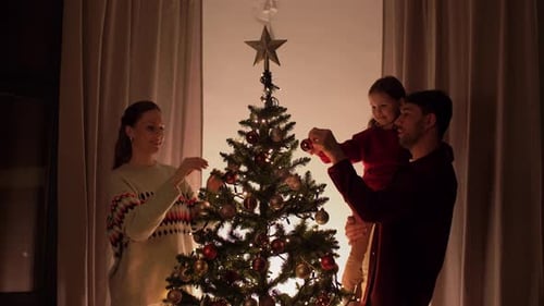 Family Decorates Christmas Tree in Warm Home