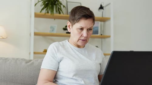 Focused Woman Working on Laptop at Home