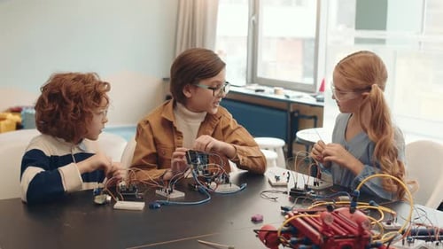 Group of Three School Kids Constructing Robots
