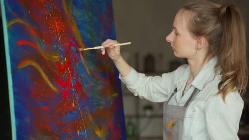 Young Woman Painting on Large Canvas in Studio