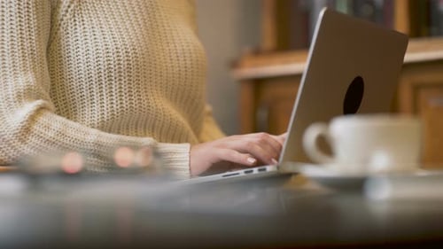 Woman Typing on Laptop Computer in Office Setting