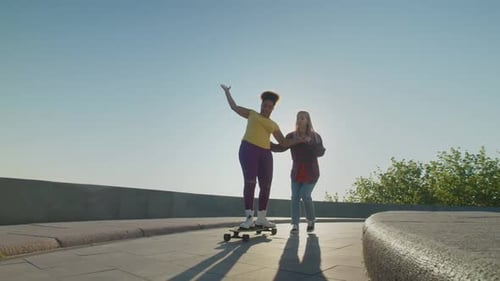 Women Friends Skateboarding in the City on Sunny Day