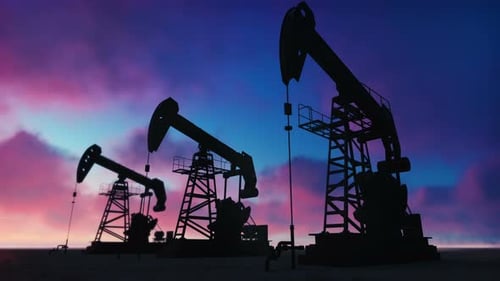 Oil Pumpjacks Silhouettes Pumping Against Colorful Sunset Sky