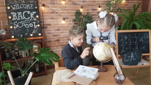 Children Learning Together with Globe and Magnifying Glass