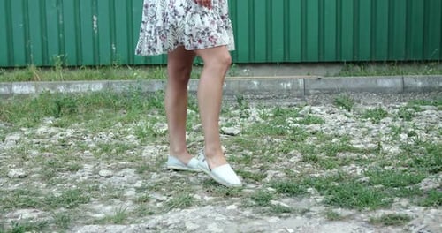 Low View of Stunning Girl in Blowing Skirt Whirls and Poses at Camera Outdoors