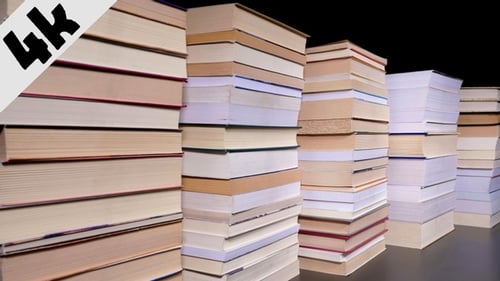 Stacks of Books Growing Taller on Table