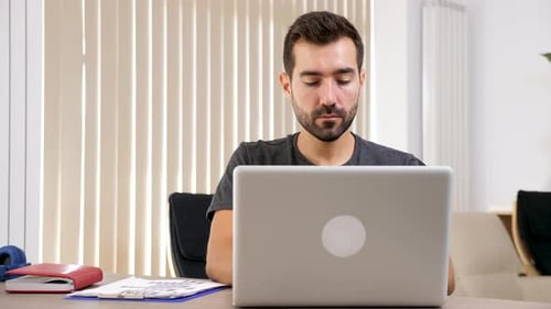 Man Typing on the Laptop in His Living Room