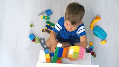 Kid Playing with Logical Toy on Floor in Children Room