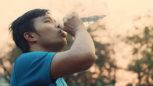 Adult Drinking Water from a Bottle Outdoors