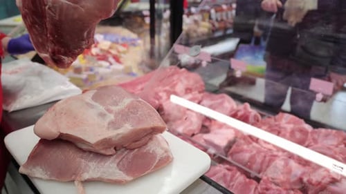 Un trozo de carne de cerdo fresca que el vendedor compró en el mostrador del mercado