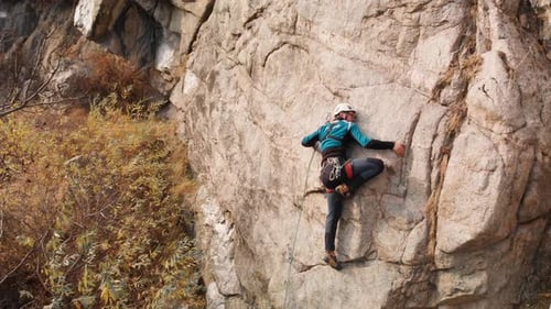 Man Athlette Climbing on the High Rock